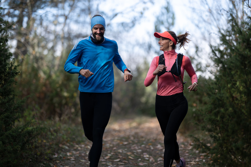 Una pareja haciendo trail running por los senderos arbolados del Monte Aloia.