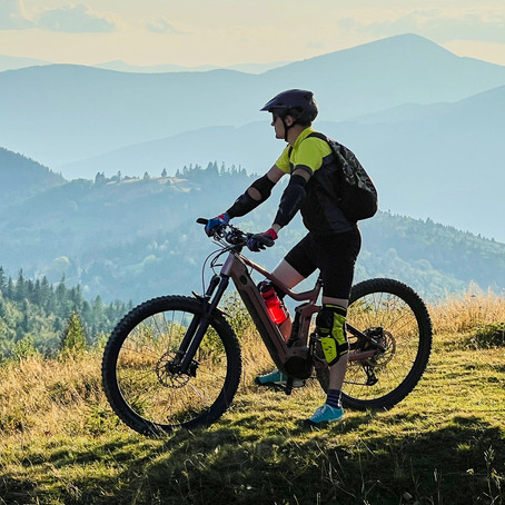 Ciclista de montaña en la cima de una colina disfrutando de las vistas panorámicas.
